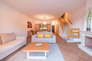 a living room with a couch and a fireplace at Acolhedora Vivenda Geminada Praia D'el Rey in Casal da Lagoa Seca +11 photos