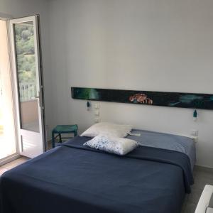 a bedroom with a blue bed with a large window at ELI&LOU avec piscine in Alata