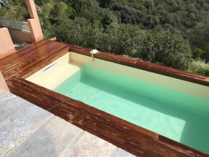 a pool on a roof with a wooden deck at ELI&LOU avec piscine in Alata