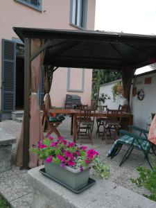 a patio with a black umbrella and flowers in a pot at Zizzihome Bed and Breakfast in Orta San Giulio