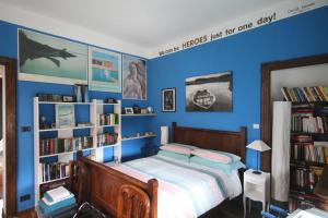 a bedroom with a bed with blue walls and book shelves at Zizzihome Bed and Breakfast in Orta San Giulio