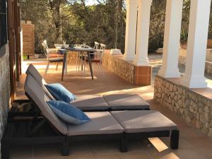 a patio with a couch and a table and chairs at Can Andreu Morna in Sant Francesc Xavier