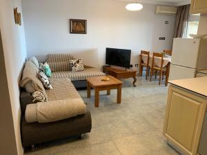 a living room with a couch and a table and a refrigerator at Beachfront apartment Mila, Ground floor in Durrës