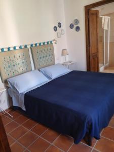 - une chambre avec un grand lit et une couverture bleue dans l'établissement Casa di Giulietta, à Cabras