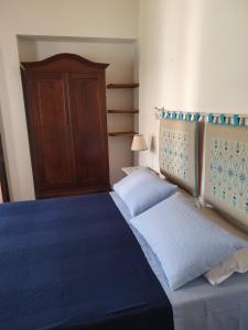 - une chambre avec 2 lits et une armoire en bois dans l'établissement Casa di Giulietta, à Cabras