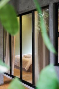 Una habitación con una cama vista a través de una ventana en Diwa Siargao Eco-House, en General Luna