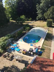 een uitzicht over een zwembad met stoelen en parasols bij la maison du parc in Dammarie-sur-Saulx