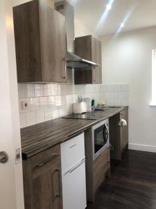 a kitchen with wooden cabinets and a counter top at Safe Move - 23 Lancaster House in Leicester