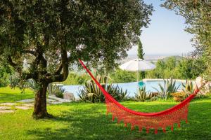 een rode hangmat hangend aan een boom in een tuin bij B&B LE AGAVI in Borso del Grappa