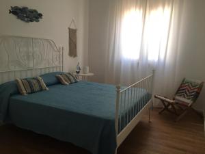 a bedroom with a bed with a blue blanket and a window at La casa accanto in Bari