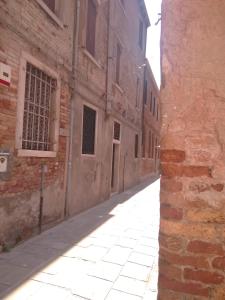 an alley in an old building with a brick wall at Sestiere Dorsoduro Venezia, a due passi dal ponte dei Pugni in Venice