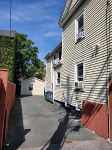 a white house with a fence next to a driveway at The Windsor Inn in Cambridge