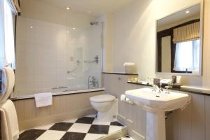 a bathroom with a sink and a toilet and a shower at Swan Hotel & Spa in Lavenham