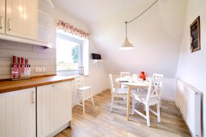 a kitchen and dining room with a table and chairs at Ferienwohnung Zollstraße 2. Etage in Bleckede +4 photos