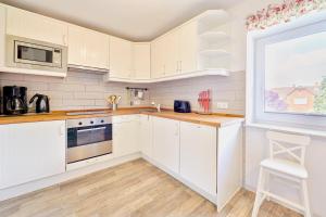 a kitchen with white cabinets and a window at Ferienwohnung Zollstraße 2. Etage in Bleckede