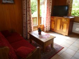 a living room with a couch and a tv and a table at Chalet * Lioutraz * in Chamonix-Mont-Blanc