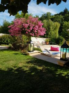 a tree with pink flowers in a yard at Sous les Remparts in Solignac