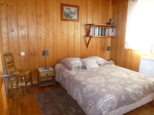 - une chambre avec un lit et un mur en bois dans l'établissement Chalet * Lioutraz *, à Chamonix-Mont-Blanc