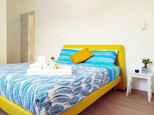 a bedroom with a yellow bed with a blue and white blanket at Pizzacalla in Pineto