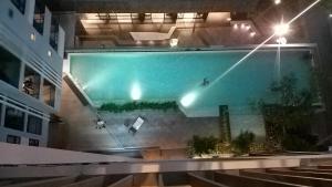 una piscina en un edificio por la noche en The BASE Central Pattaya by NKL, en Pattaya central