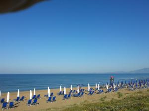 un grupo de sillas y sombrillas en una playa en Hotel Della Baia, en Baia Domizia