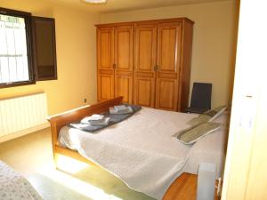 マサネッド・ダ・ラ・セルバにあるCan Dalemusのベッドルーム1室(ベッド1台付)、木製キャビネットが備わります。