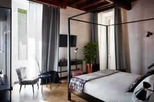 a bedroom with a bed and a chair and a desk at NAMAN HOTELLERIE - Margutta in Rome