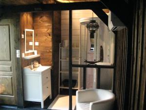 Habitación con baño con lavabo y silla. en Les Troglos de Beaulieu, en Loches