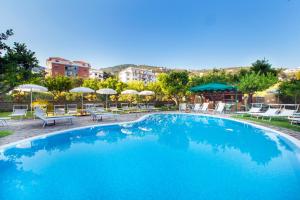 a large blue swimming pool with chairs and umbrellas at Hotel Antiche Mura in Sorrento