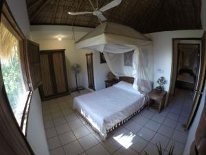una camera da letto con un letto a baldacchino e un ombrello di Casa Aditi a Mazunte