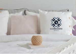 a pile of pillows on a bed with a tray at No.4 Ludbourne Hall in Sherborne