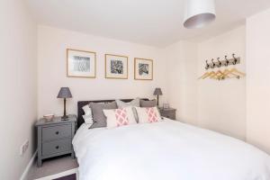 a white bedroom with a bed and two night stands at No.4 Ludbourne Hall in Sherborne