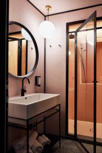 bagno con lavandino e specchio di NAMAN HOTELLERIE - Margutta a Roma