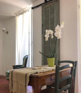 Una mesa de comedor con un jarrón de flores encima. en Studio Olive, en La Ciotat