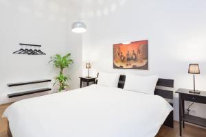 Un dormitorio con una cama blanca y un cuadro en la pared. en Labyrinth, en Berlín