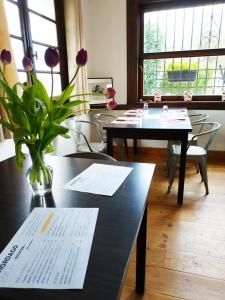una habitación con mesas y sillas y un jarrón con flores en Maison Hordago Chambres d'hôtes, en Sare