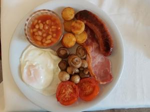 トーキーにあるGrosvenor House Hotelの卵ソーセージ豆とトマトを添えた朝食用の皿
