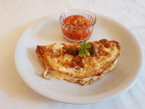 a plate of food with a omelet and a cup of beans at Grosvenor House Hotel in Torquay