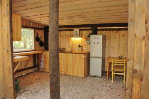 a kitchen with a refrigerator and a table in a cabin at Kuuli Puhkemajad in Tagaranna
