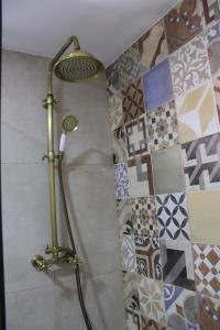 y baño con ducha y azulejos en la pared. en A Casinha da Padaria, Soajo, en Soajo