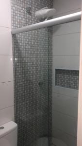 uma casa de banho com uma cabina de duche em vidro e um WC. em Hotel Novo Oriente Brás em São Paulo