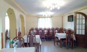 a dining room with a table and a bunch of chairs at Pensiunea Argela in Argel