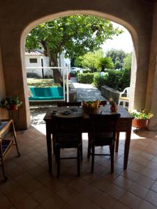 stół i krzesła na patio z łukiem w obiekcie Villetta panoramica w mieście Maratea