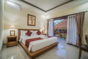sypialnia z dużym łóżkiem i oknem w obiekcie Sriwedari 40 Ubud w mieście Ubud