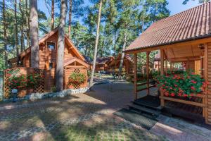 a log cabin with flowers in front of it at SOLEI in Pobierowo