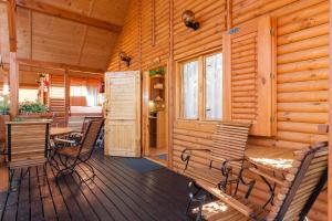 a porch with chairs and a table in a cabin at SOLEI in Pobierowo
