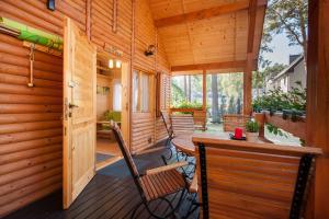 a wooden porch with chairs and a table on a deck at SOLEI in Pobierowo +13 photos