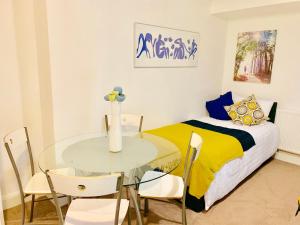 Schlafzimmer mit einem Bett, einem Glastisch und Stühlen in der Unterkunft 2 Bedrooms Modern Central London Apartment, Full Kitchen, 5 minutes Tube Station in London