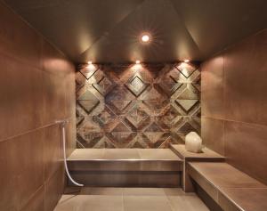 a bathroom with a shower with a stone wall at Hotel Silvretta in Serfaus