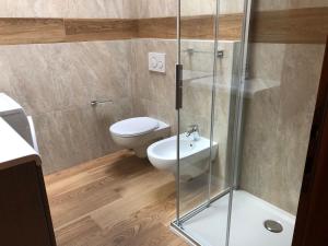 a bathroom with a toilet and a glass shower at Casa Berlanda in Fiera di Primiero